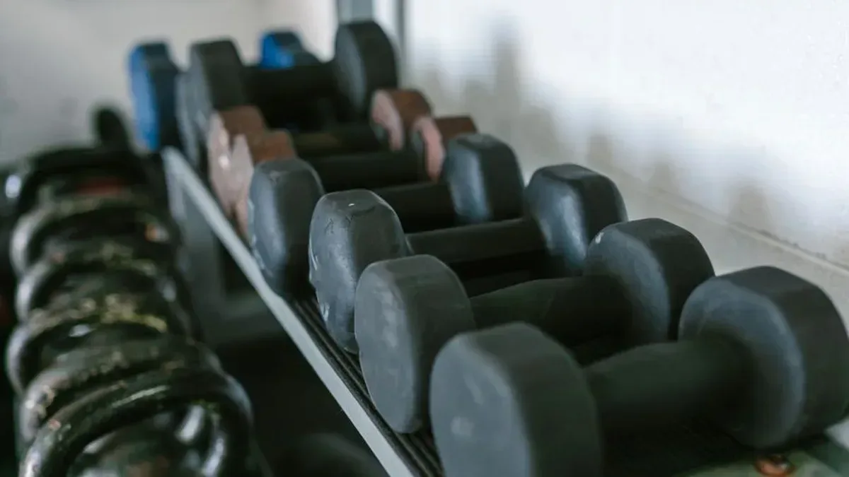 Rameur, haltères et tapis de course empilés dans un garage avant un don associatif